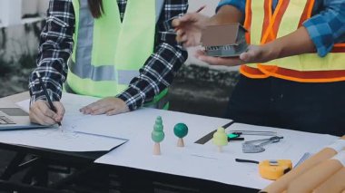 İnşaat işçisi, plan üzerinde çalışıyor.