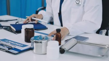 Steteskoplu bir doktor ve haplı bir şişe. Stetoskop ve şırıngayla beyaz önlüklü bir doktor.