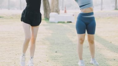 Parkta egzersiz yapan iki genç kadın.