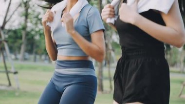 Parkta egzersiz yapan iki genç Asyalı kadın.