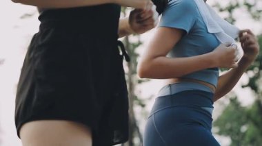 Parktaki çimlerde egzersiz yapan genç bir kadın..