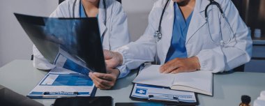 Erkek ve kadın doktorlar bir hastane odasında toplantı yapıyorlar..