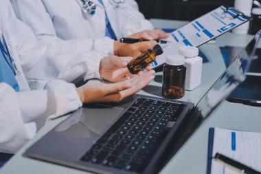 Erkek ve kadın doktorlar bir hastane odasında toplantı yapıyorlar..