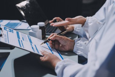 Erkek ve kadın doktorlar bir hastane odasında toplantı yapıyorlar..