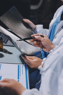 Erkek ve kadın doktorlar bir hastane odasında toplantı yapıyorlar..