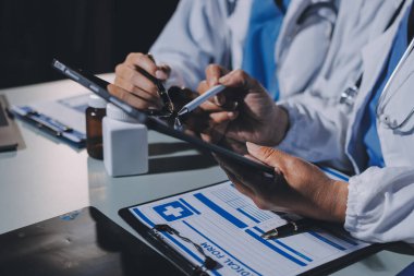 Erkek ve kadın doktorlar bir hastane odasında toplantı yapıyorlar..