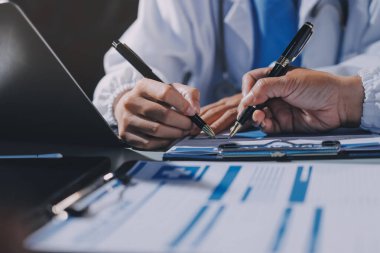 Erkek ve kadın doktorlar bir hastane odasında toplantı yapıyorlar..