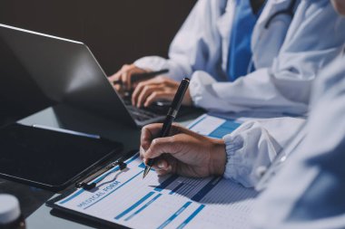 Erkek ve kadın doktorlar bir hastane odasında toplantı yapıyorlar..