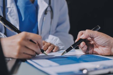 Erkek ve kadın doktorlar bir hastane odasında toplantı yapıyorlar..