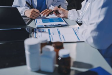 Erkek ve kadın doktorlar bir hastane odasında toplantı yapıyorlar..