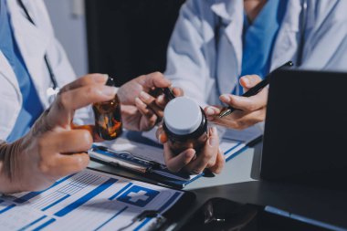 Erkek ve kadın doktorlar bir hastane odasında toplantı yapıyorlar..