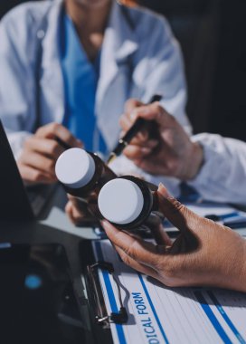 Erkek ve kadın doktorlar bir hastane odasında toplantı yapıyorlar..