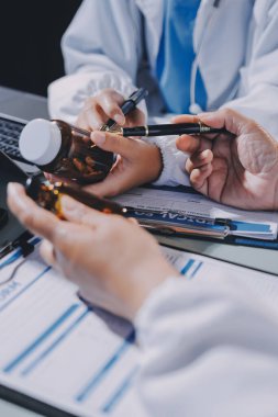 Erkek ve kadın doktorlar bir hastane odasında toplantı yapıyorlar..