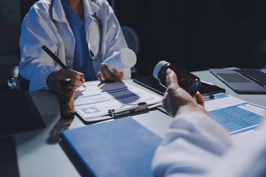 Erkek ve kadın doktorlar bir hastane odasında toplantı yapıyorlar..