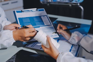 Erkek ve kadın doktorlar bir hastane odasında toplantı yapıyorlar..