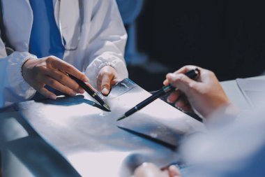 Erkek ve kadın doktorlar bir hastane odasında toplantı yapıyorlar..