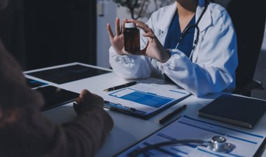 Uzman doktor bir hastaya ilaç götürmeyi açıklıyor. Sağlık ve İlaç danışmanlığı.