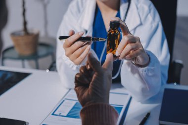 Uzman doktor bir hastaya ilaç götürmeyi açıklıyor. Sağlık ve İlaç danışmanlığı.