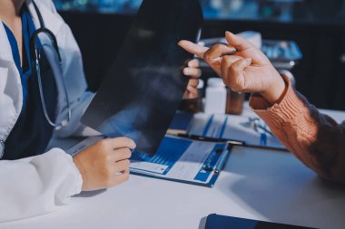 Doktor, emekliye ayrılmış yaşlı kadına akciğer röntgeni çeken hastanın sağlık ve hayat sigortası planlarını kullanarak hastane bakım evindeki hastalara tedavi yöntemlerini anlattı.