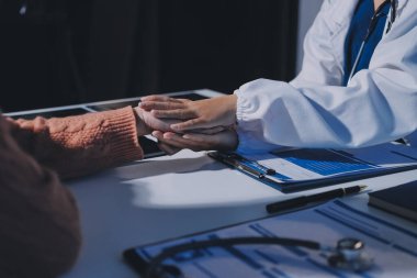 Asyalı kadın elleri yaşlı kadın ellerine dokunuyor hastanede yaşlılara yardım eden eller.