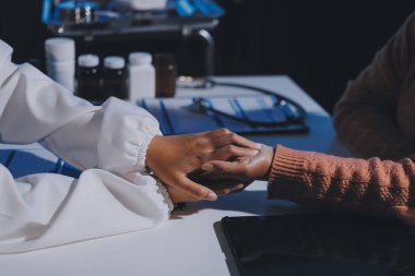 Asyalı kadın elleri yaşlı kadın ellerine dokunuyor hastanede yaşlılara yardım eden eller.