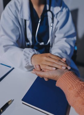 Asyalı kadın elleri yaşlı kadın ellerine dokunuyor hastanede yaşlılara yardım eden eller.