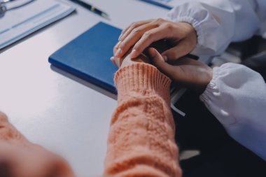 Asyalı kadın elleri yaşlı kadın ellerine dokunuyor hastanede yaşlılara yardım eden eller.