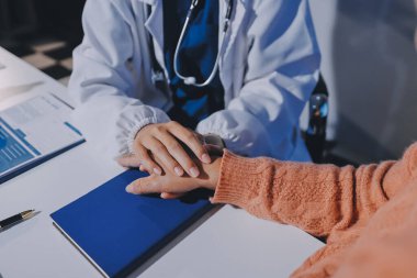 Asyalı kadın elleri yaşlı kadın ellerine dokunuyor hastanede yaşlılara yardım eden eller.