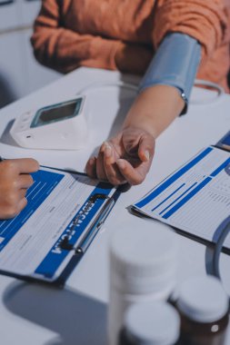 Hemşire masada yaşlı kadının kan basıncını ölçtü, yakın çekim. Üst düzey nesillere yardımcı olmak