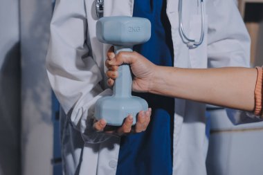 Klinikte dambıllar, fizik tedavi konsepti kullanan hastalarla fizyoterapist eğitimi