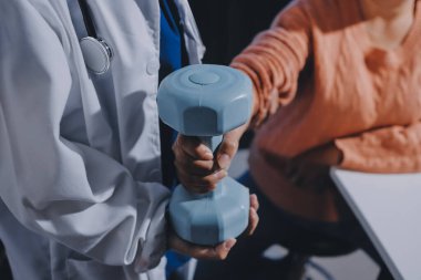 Klinikte dambıllar, fizik tedavi konsepti kullanan hastalarla fizyoterapist eğitimi