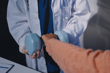 Klinikte dambıllar, fizik tedavi konsepti kullanan hastalarla fizyoterapist eğitimi