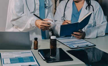 Erkek ve kadın doktorlar bir hastane odasında toplantı yapıyorlar..