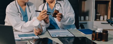 Erkek ve kadın doktorlar bir hastane odasında toplantı yapıyorlar..