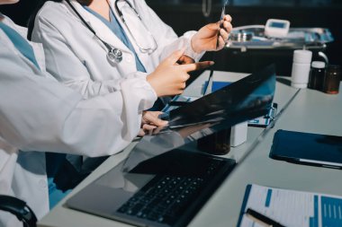 Erkek ve kadın doktorlar bir hastane odasında toplantı yapıyorlar..