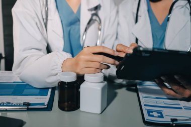 Erkek ve kadın doktorlar bir hastane odasında toplantı yapıyorlar..