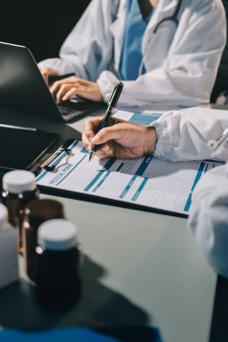 Erkek ve kadın doktorlar bir hastane odasında toplantı yapıyorlar..