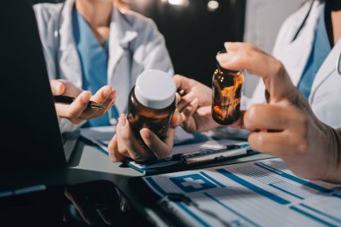 Erkek ve kadın doktorlar bir hastane odasında toplantı yapıyorlar..