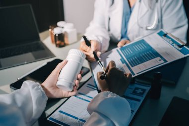 Erkek ve kadın doktorlar bir hastane odasında toplantı yapıyorlar..