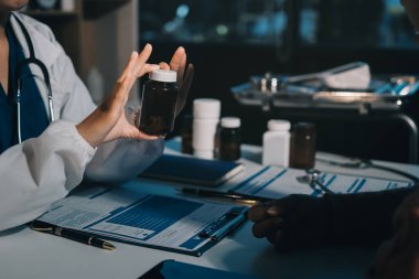 Uzman doktor bir hastaya ilaç götürmeyi açıklıyor. Sağlık ve İlaç danışmanlığı.