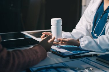 Uzman doktor bir hastaya ilaç götürmeyi açıklıyor. Sağlık ve İlaç danışmanlığı.