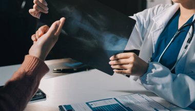 Doktor, emekliye ayrılmış yaşlı kadına akciğer röntgeni çeken hastanın sağlık ve hayat sigortası planlarını kullanarak hastane bakım evindeki hastalara tedavi yöntemlerini anlattı.