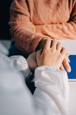 Asyalı kadın elleri yaşlı kadın ellerine dokunuyor hastanede yaşlılara yardım eden eller.