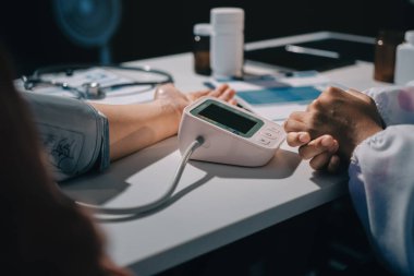 Hemşire masada yaşlı kadının kan basıncını ölçtü, yakın çekim. Üst düzey nesillere yardımcı olmak