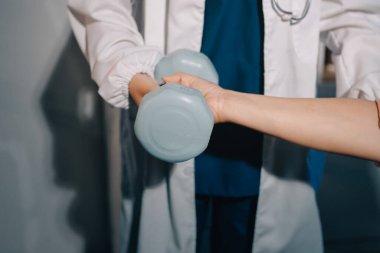 Klinikte dambıllar, fizik tedavi konsepti kullanan hastalarla fizyoterapist eğitimi