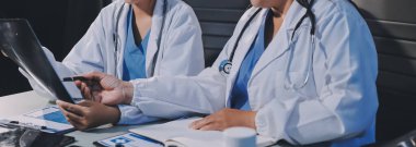 Erkek ve kadın doktorlar bir hastane odasında toplantı yapıyorlar..