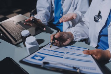 Erkek ve kadın doktorlar bir hastane odasında toplantı yapıyorlar..