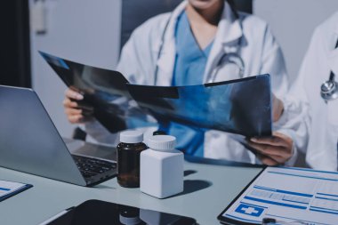 Erkek ve kadın doktorlar bir hastane odasında toplantı yapıyorlar..