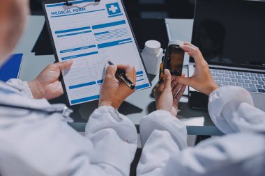 Erkek ve kadın doktorlar bir hastane odasında toplantı yapıyorlar..