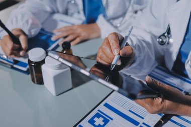 Erkek ve kadın doktorlar bir hastane odasında toplantı yapıyorlar..